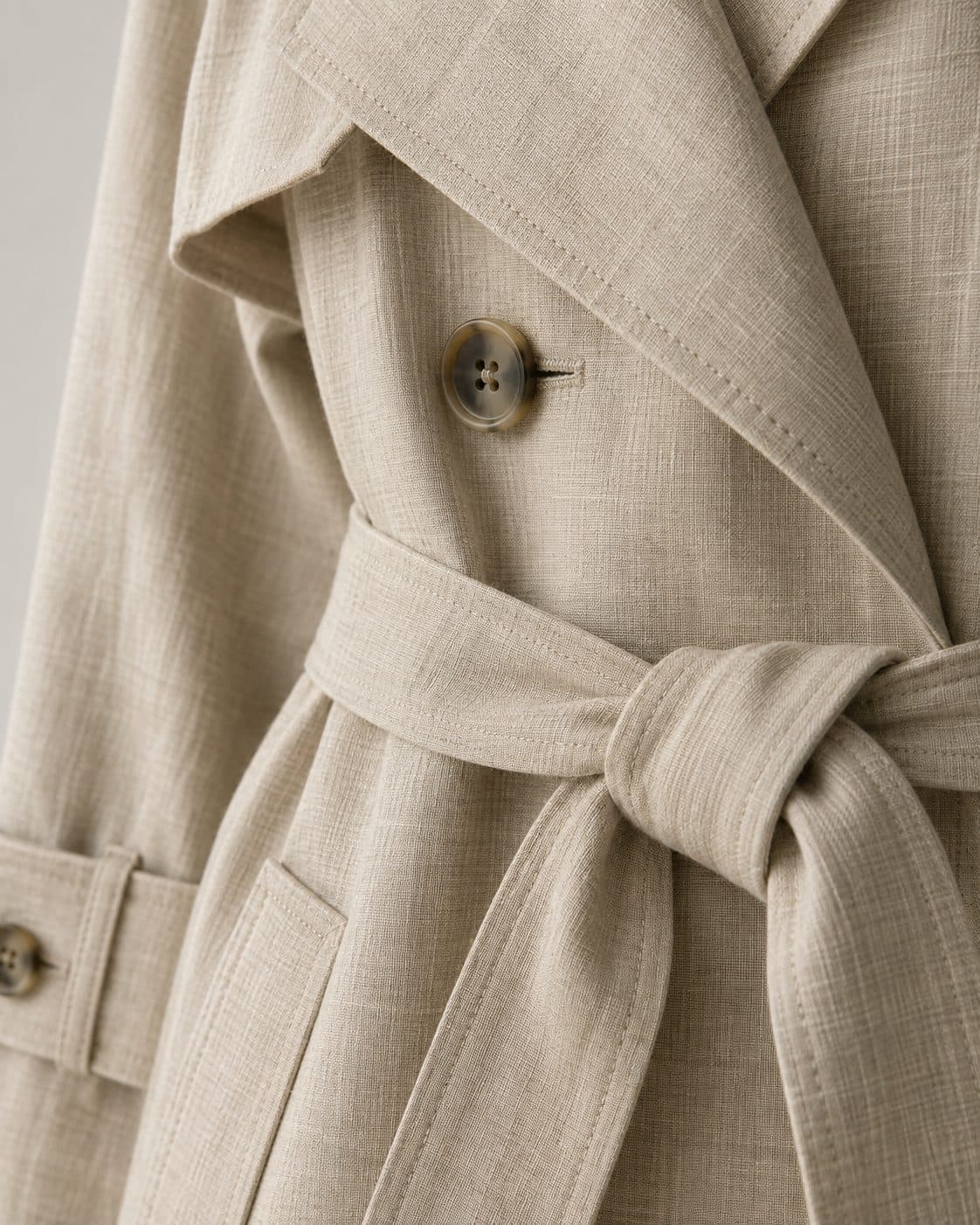 Detail of the linen trench lapel, horn button and belt